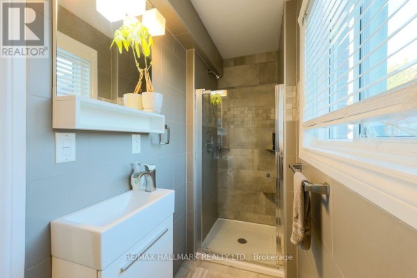 Bathroom with a modern vanity, square sink, and a glass-enclosed shower. - 5a Scotia Avenue, Toronto