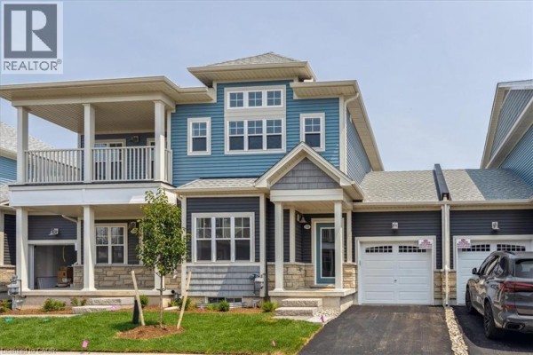Exterior of a blue and grey townhouse complex with attached garages and balconies. - 5b Shores Lane, Crystal Beach
