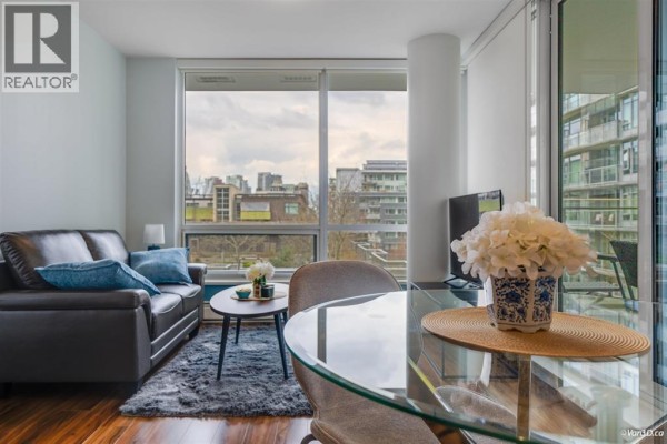 Living room with dark leather sofa, coffee table, and glass dining table. - 5xx 159 2nd Avenue, Vancouver