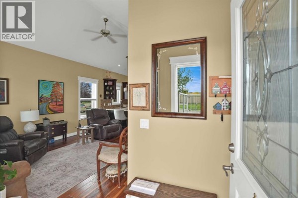 Entranceway with a mirrored wall and a view through the glass front door to the exterior. - 6, 20 River Heights View, Cochrane