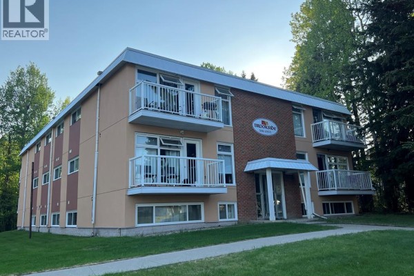 Exterior side view of Brookside apartments with beige and brown facade and white balconies. - 6, 506 41 Street, Edson