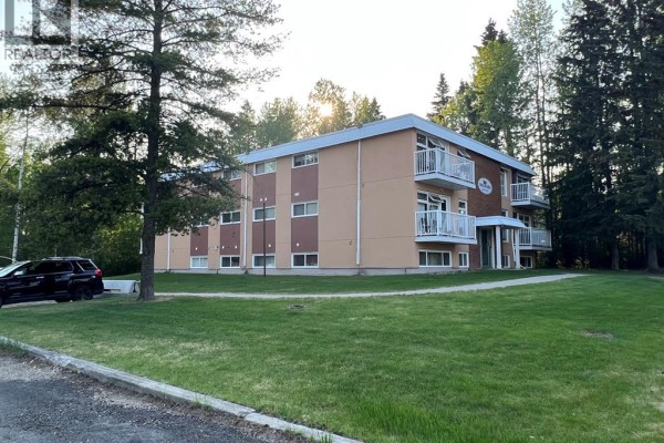 Exterior side view of Brookside apartments surrounded by trees and grass. - 6, 506 41 Street, Edson