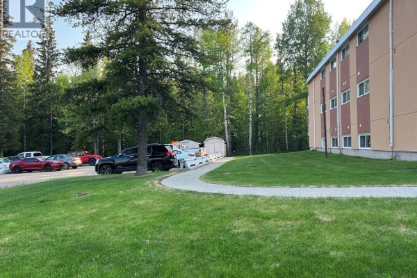 Parking lot with cars and storage sheds to the side of the apartment building. - 6, 506 41 Street, Edson