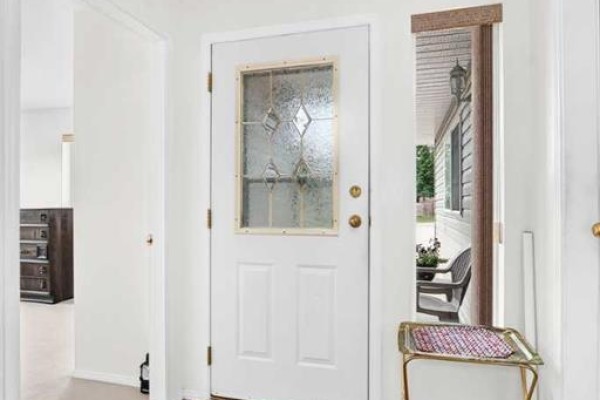 Interior view of a white front door with a decorative glass insert. - 6, 6500 40 Avenue, Stettler