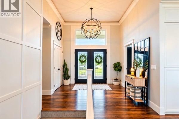 Spacious entryway with double glass doors, dark wood floors, and a large geometric chandelier. - 6, 715034 Range Road 73, Rural Grande Prairie No  1, County Of