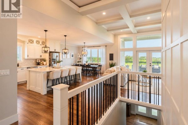 Open concept living space with a white kitchen, dining area, and living room with large windows. - 6, 715034 Range Road 73, Rural Grande Prairie No  1, County Of