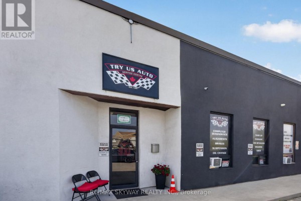 Front exterior of a commercial auto repair shop with a dark grey accent wall. - 6 - 181 Rutherford Road, Brampton