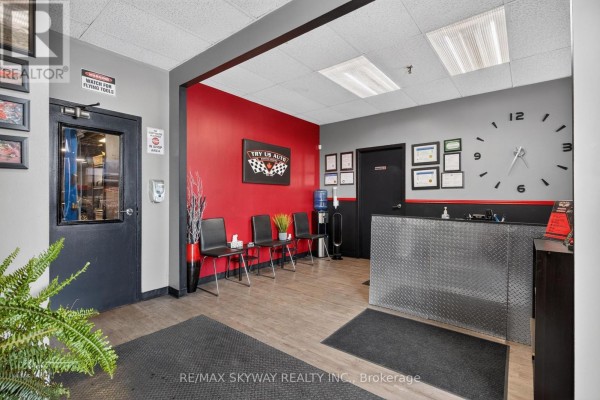Interior waiting area of an auto repair shop with red and grey walls. - 6 - 181 Rutherford Road, Brampton