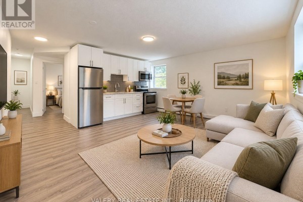 Open concept living and kitchen area with sectional sofa, dining table, and white cabinets. - 6 - 20 Craig Street, London South