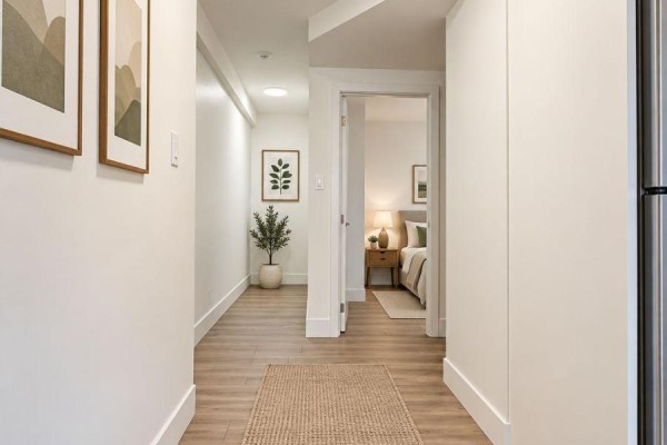 Interior hallway with white walls, light wood laminate flooring, and an open doorway to a bedroom. - 6 - 20 Craig Street, London South