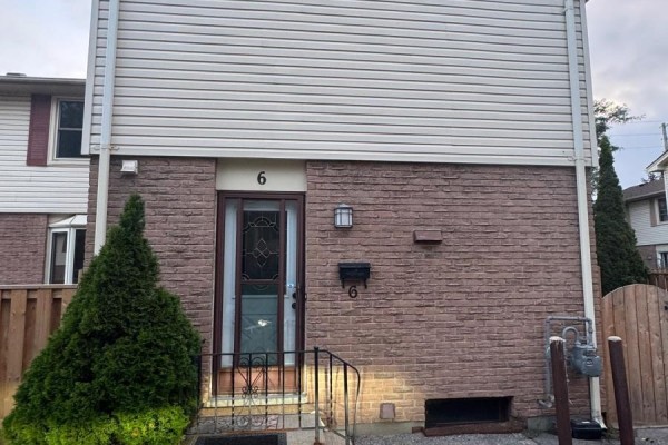 Front exterior of townhouse unit 6 with a dark wood front door and sidelight. - 6 - 230 Clarke Road, London East