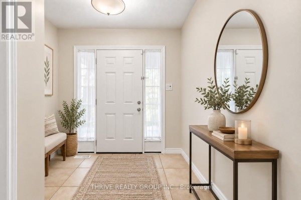 Foyer with white double doors, tile flooring, a bench, and a console table with mirror. - 6 - 400 Skyline Avenue N, London North