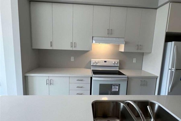Close-up of kitchen countertops, sink, faucet, and white stove. - 6 - 527 Shaver Road, Hamilton