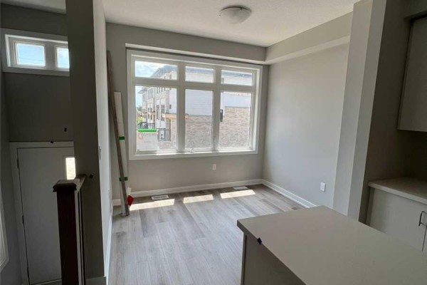 Dining area with large window, light grey walls, and wood-look flooring. - 6 - 527 Shaver Road, Hamilton