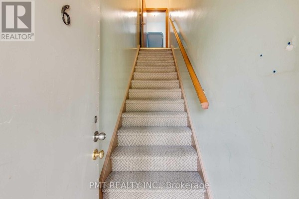 Carpeted staircase with wood banister, leading up from an entrance with light grey walls and number 6. - 6 - 58 Leyton Avenue, Toronto