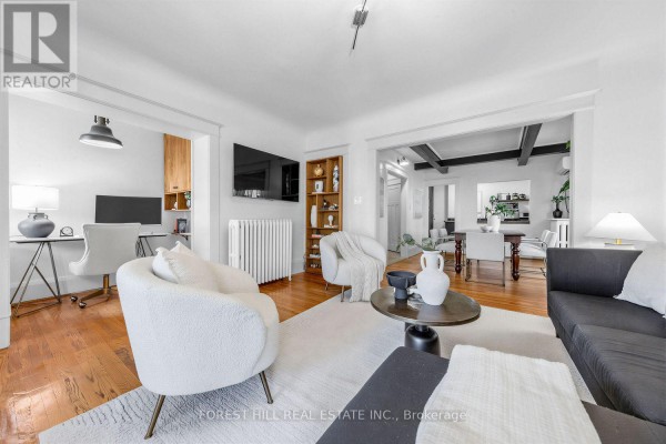 Living room with hardwood floors, white rug, black sofa, and a desk area. - 6 - 68 Kendal Avenue, Toronto