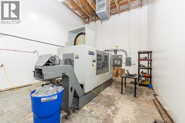 Wide view of a commercial workshop with a machining center, compressor, and workbenches. - 6 1770 Mclean Avenue, Port Coquitlam