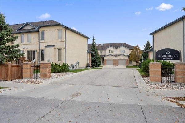 Entrance to Shorehill Drive, Winnipeg with brick pillars and townhouse buildings in the background. - 6 25 Shorehill Drive, Winnipeg