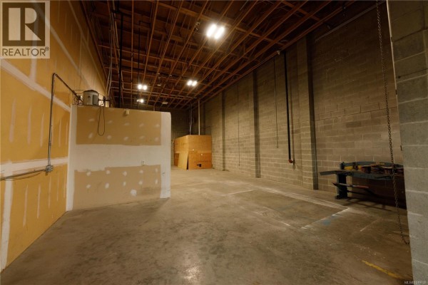 Spacious commercial unit with a large door and minimal interior partitions. - 6 2535 Mccullough Rd, Nanaimo