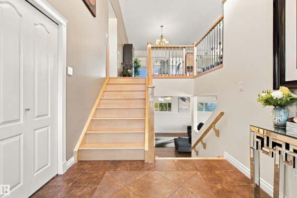 Foyer with a light wood staircase, tile flooring, and closet doors. - #6 61130 Rr 465, Rural Bonnyville M D 