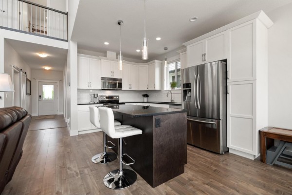 Dining area with a wooden table and chairs, windows, and a crystal chandelier. - 6 7328 Morrow Road, Agassiz, Agassiz