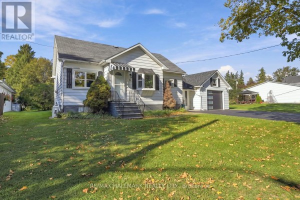 Front view of a white bungalow with a striped awning over the front window and a paved driveway. - 6 Albert Street, Whitby