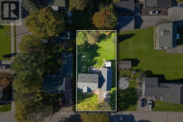 Aerial view showing the property lot with a white bungalow, detached garage, and surrounding trees and houses. - 6 Albert Street, Whitby