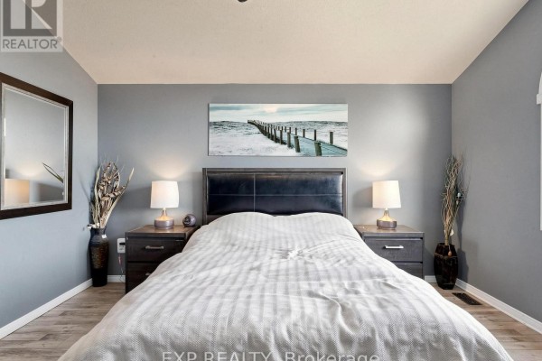 Bedroom with king bed, nightstands, lamps, and mirror - 6 Booth Lane Barrie