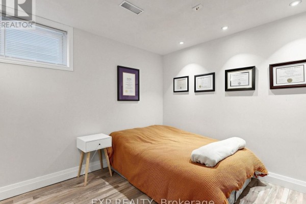 Bedroom with bed, nightstand, and framed certificates - 6 Booth Lane Barrie