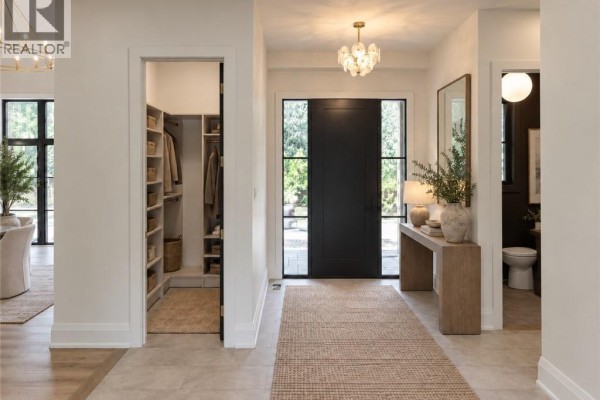 Interior entryway with a large dark door, console table, and a walk-in closet. - 6 Bridlewood Crescent, Kitchener