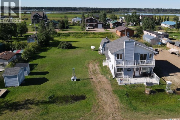Aerial view of the light blue house and surrounding property with scattered sheds and other houses in the distance. - 6 Bronco Drive, Delaronde Lake