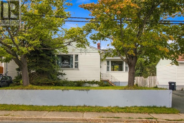 Front view of a white house with trees and a driveway on a sunny day. - 6 Cherry Hill Road, St  John S