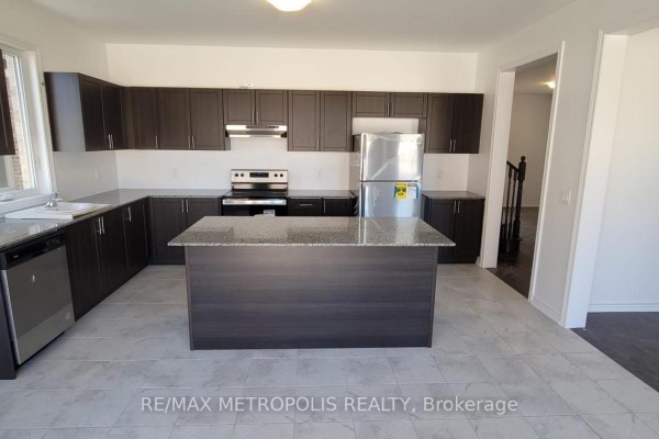 Modern kitchen with dark brown cabinets, granite counters, stainless steel appliances, and an island. - 6 Corbett Street, Southgate