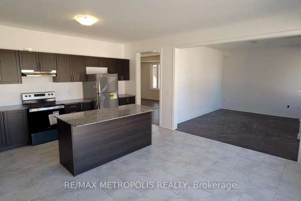 View of the modern kitchen and adjoining living area with white walls and dark flooring. - 6 Corbett Street, Southgate
