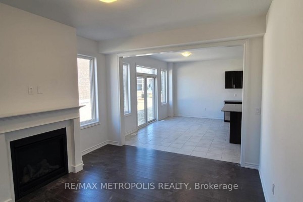 Living room with a fireplace and doorway leading to the kitchen and backyard patio doors. - 6 Corbett Street, Southgate
