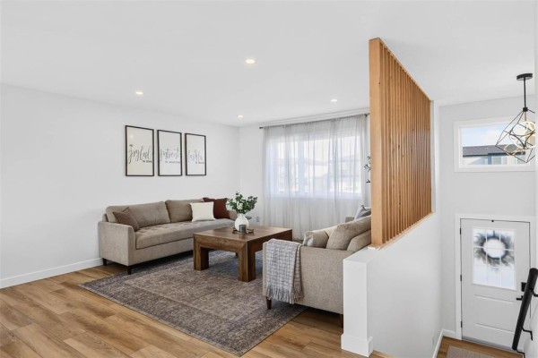 Living room area with a sectional sofa, a coffee table, and a view of the entryway and staircase. - 6 Falcon Bay, Ste Anne