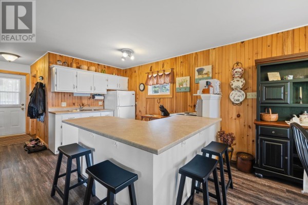 Bright kitchen with white cabinetry, a central island, and a door leading outside. - 6 Grandview Drive, South West Lot 16