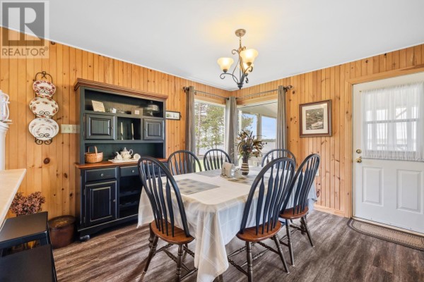 Dining area with a wooden table, black chairs, and large windows overlooking the yard. - 6 Grandview Drive, South West Lot 16