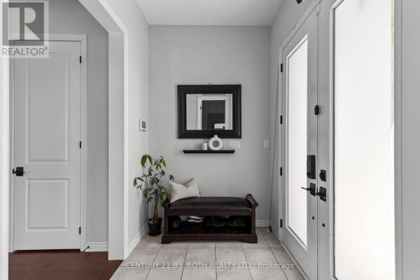 Interior foyer with tile floor, double glass doors, a bench, and a small plant. - 6 Henderson Street, Essa