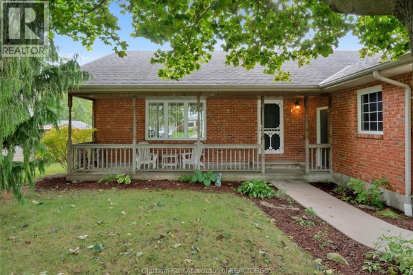 Close-up of the covered front porch with seating, brick exterior, and landscaping. - 6 James Street, Blenheim