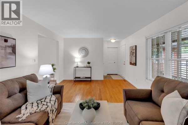 Living room with hardwood floors, two sofas, a console table, and an entrance door. - 6 James Street, Blenheim