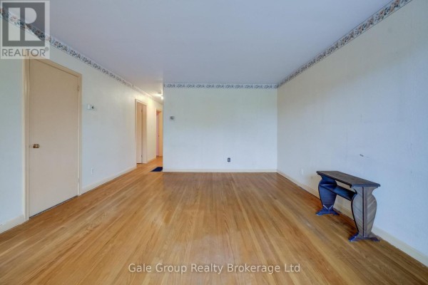 Wide view of the living room with hardwood floors, interior doors, and a console table. - 6 Langstone Crescent, Halton Hills