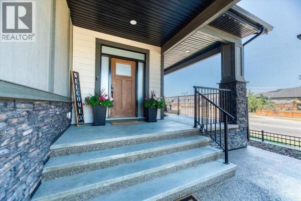 Interior hallway with light wood-look tile flooring, beige walls, and double doors leading to a dining area. - 6 Legacy Woods Crescent Se, Calgary