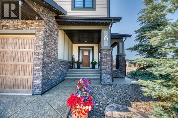 Front entryway with a wooden door, glass panels, light wood-look tile flooring, and a seating bench. - 6 Legacy Woods Crescent Se, Calgary