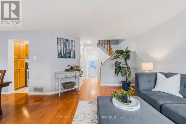 Open-concept living and dining area with light grey walls, hardwood floors, and a view of the staircase and hallway. - 6 Maravista Drive, Ottawa