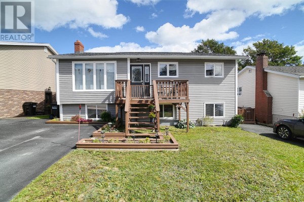 Front exterior of a grey house with a wooden deck, front door, and manicured lawn. - 6 Noad Place, St  John S