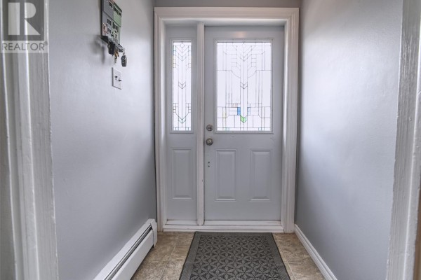 Interior entryway with light grey walls, a white door with frosted glass panels, and a dark grey mat. - 6 Noad Place, St  John S