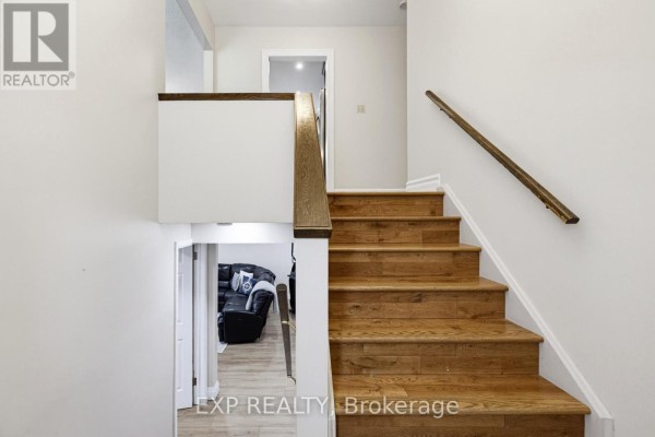 Wooden staircase with oak treads and banister leading down to a living room. - 6 Palace Street, Caledon