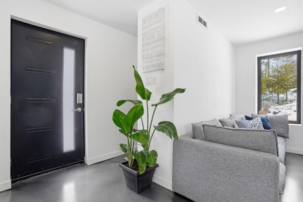 Exterior of a modern detached garage with a black roll-up door. - 6 Rue Du Butor, Val Des Monts