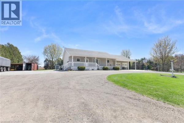 Side view of a light grey ranch house with white trim, vinyl siding and green grass lawn. - 6 Scott Street, Delhi